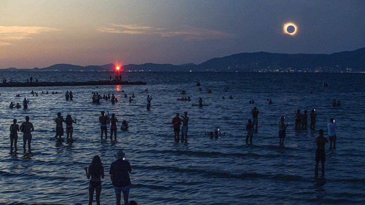 Miles de personas disfrutan del eclipse en Playa de Palma.