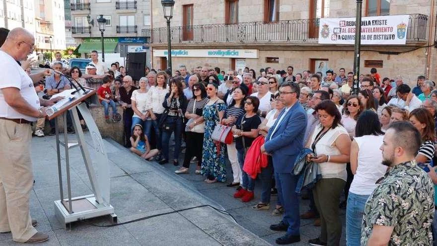 Los miembros de la plataforma ciudadana contra el desmantelamiento de la Comisaría de Redondela, ayer, leen el manifiesto. // José Lores