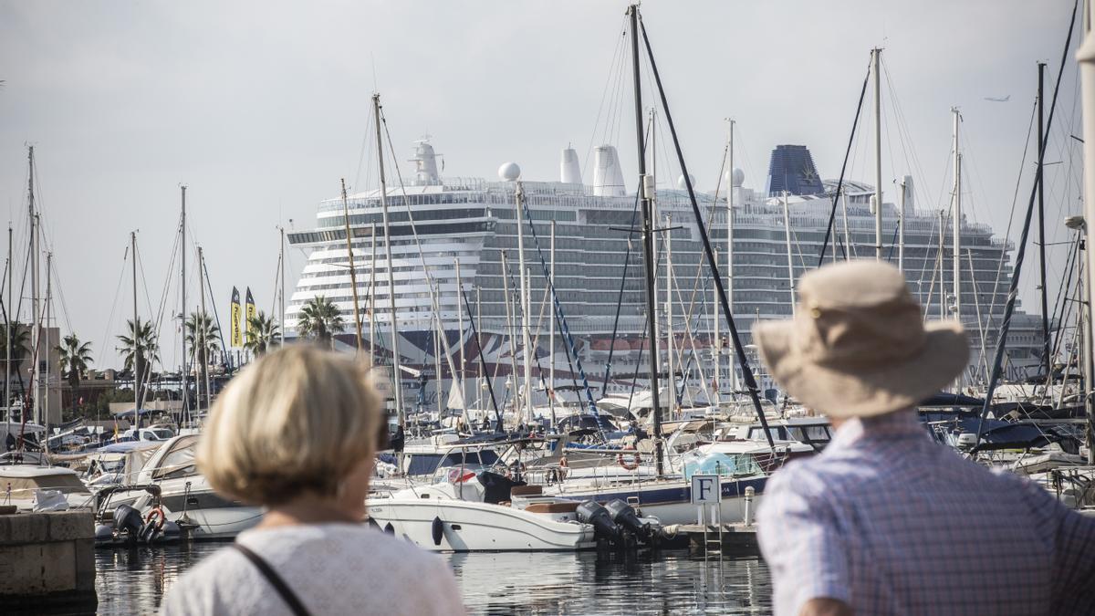 Una pareja de turistas observa el crucero Iona, uno de los barcos que ha visitado esta semana Alicante