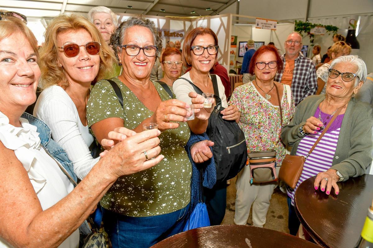 Un grupo de amigas brinda con un chupito de vino durante la celebración de la feria.