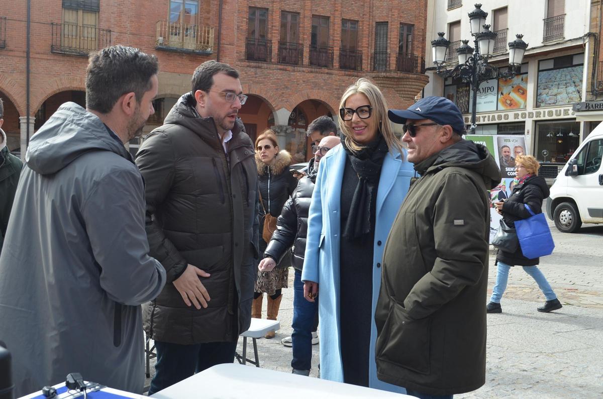 De izquierda a derecha, el secretario provincial del PSOE en Zamora, Antidio Fagúndez; el presidente del Principado de Asturias, Adrián Barbón; la secretaria local del PSOE en Benavente, Patricia Martín; y un simpatizante en la Plaza Mayor de Benavente.
