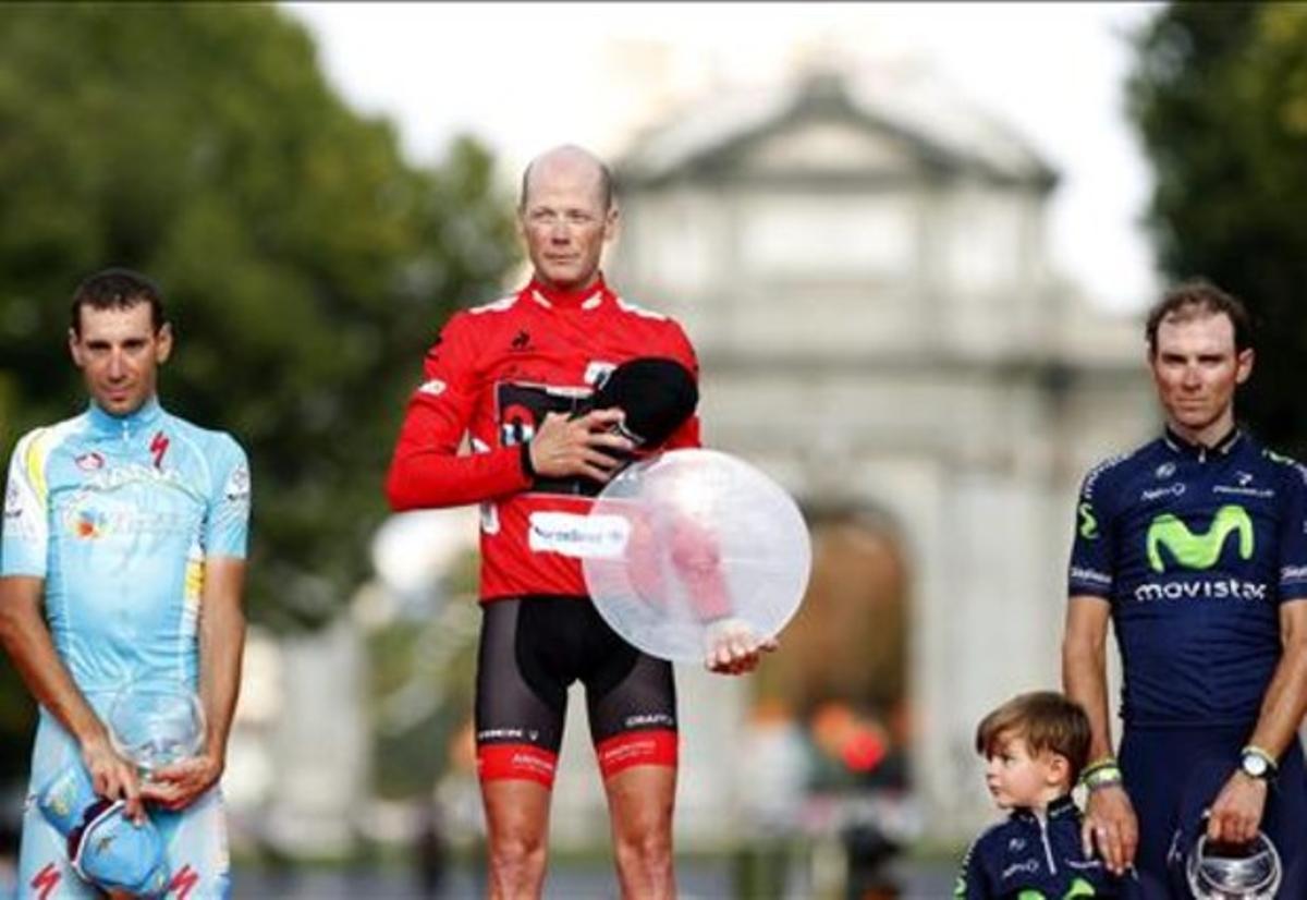 Vincenzo Nibali (esquerra) i Alejandro Valverde, amb el seu fill Pablo, acompanyen Chris Horner al podi de La Cibeles, de Madrid.