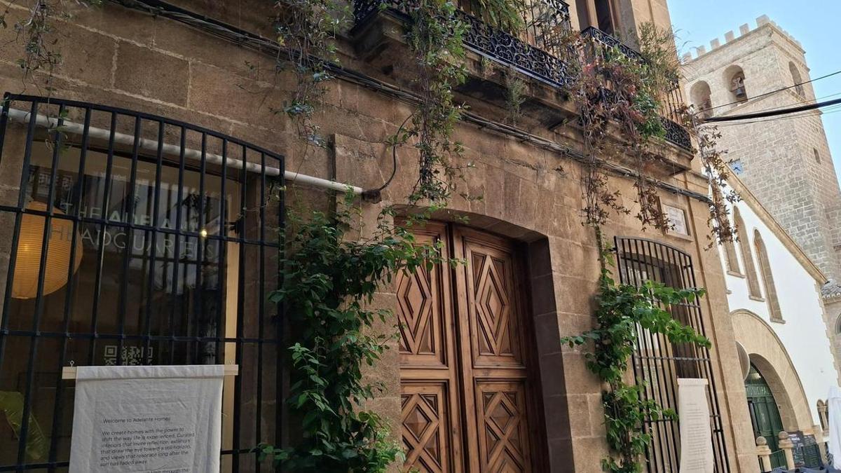 La fachada de piedra tosca de la casa del siglo XIX, el Mercat Municipal y la torre de la iglesia gótica