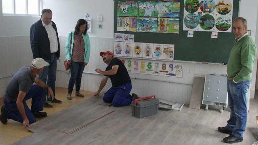 Trabajadores instalan la tarima flotante en el aula principal.