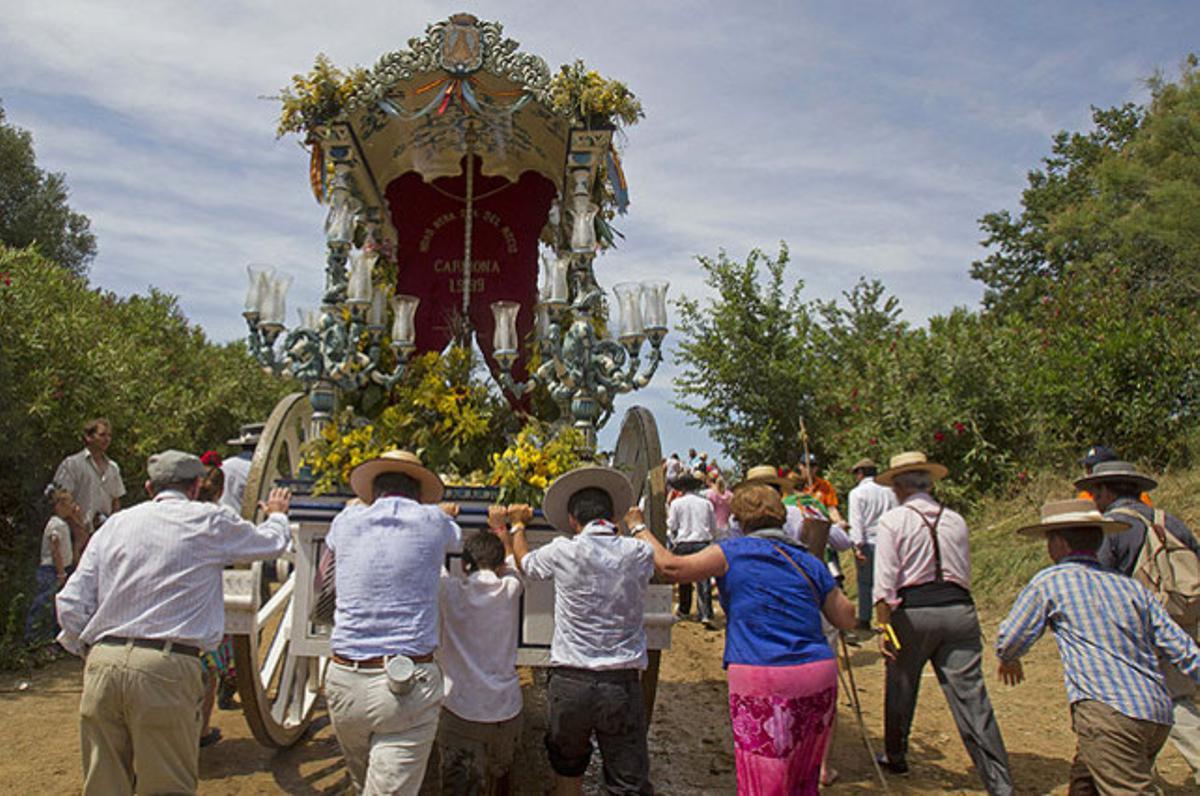 ’Rocieros’ empenyen la carreta del Simpecado de la seva germandat en el pelegrinatge cap al Rocío, on aquest cap de setmana se celebren els actes centrals de la romeria, a Aznalcázar (Sevilla).