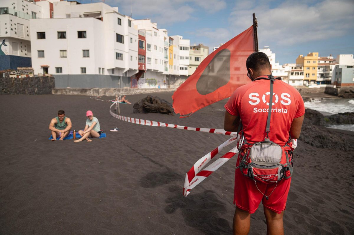 Lifeguard removing the barrier after swimming restrictions were lifted at Playa Jardín, Puerto de la Cruz, on June 17.