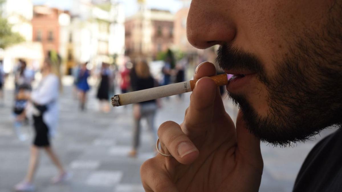 Un hombre fuma en la vía pública en Córdoba.