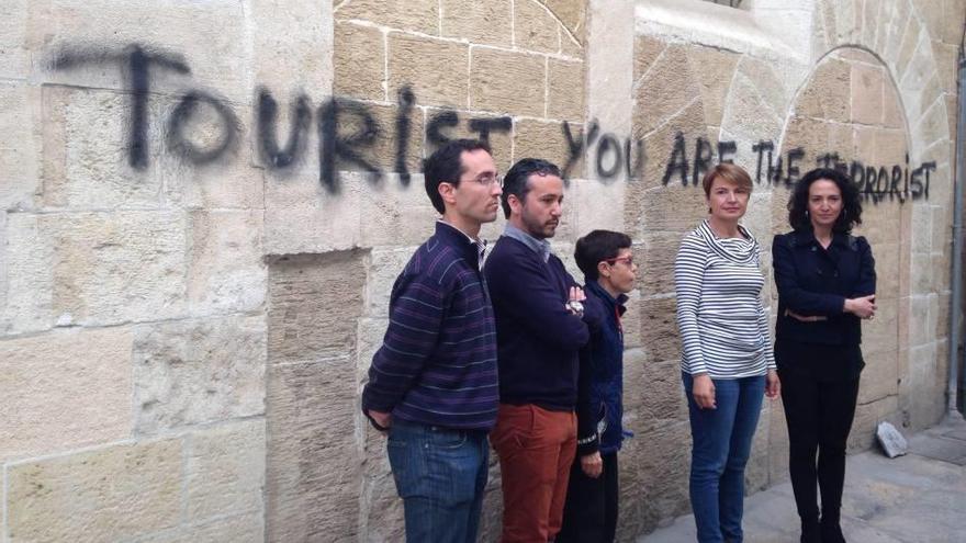 Marga Durán, portavoz del PP, frente a una de las pintadas contra el turismo.