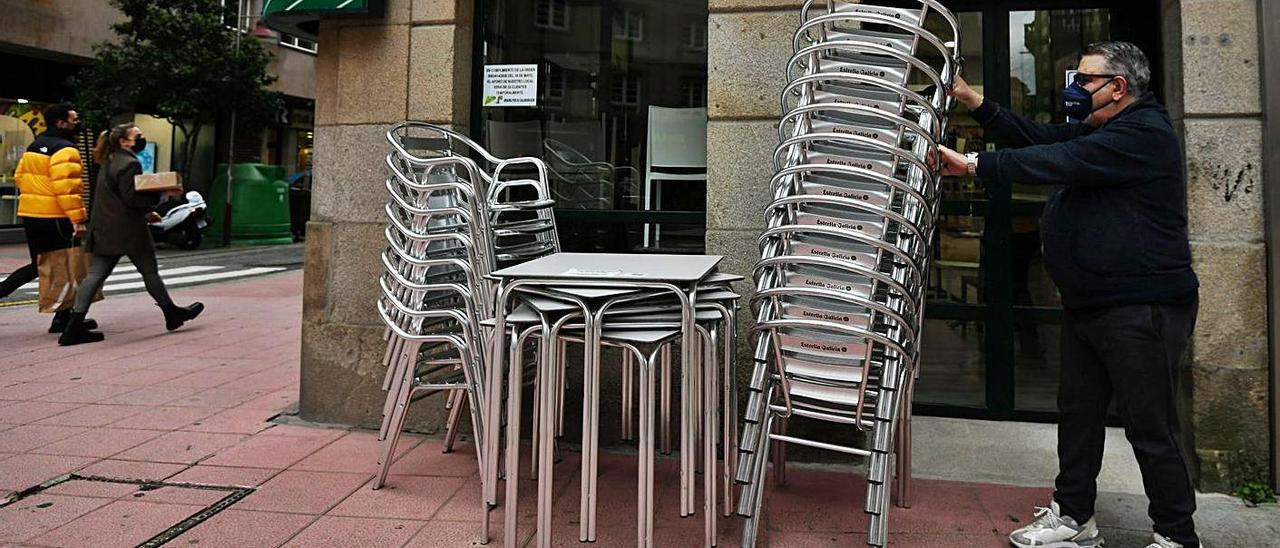 Un hombre prepara el material para su terraza de hostelería en el centro de Pontevedra. |   // GUSTAVO SANTOS