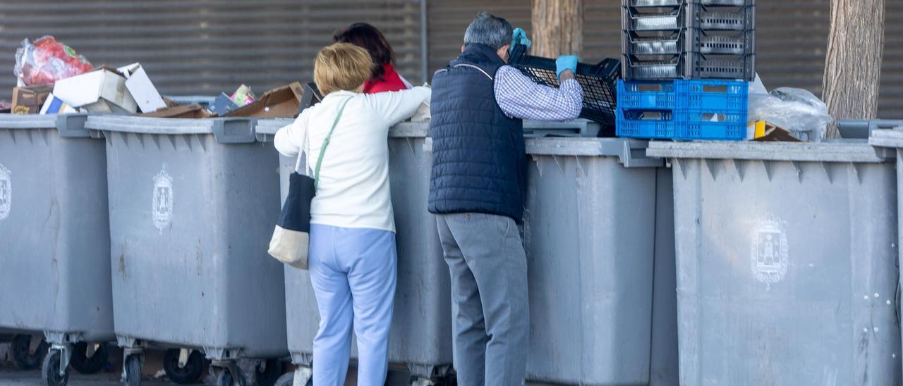 Personas buscando en los contenedores del mercado en Teulada.