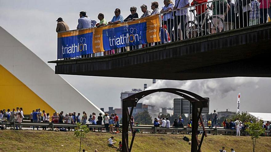 Sobre estas líneas, público en el transcurso del Campeonato del Mundo de duatlón, celebrado en Avilés en 2016.  A la derecha, arriba, asistentes al Mundial de 2016. Abajo, dos deportistas españoles en la prueba. | R. S.