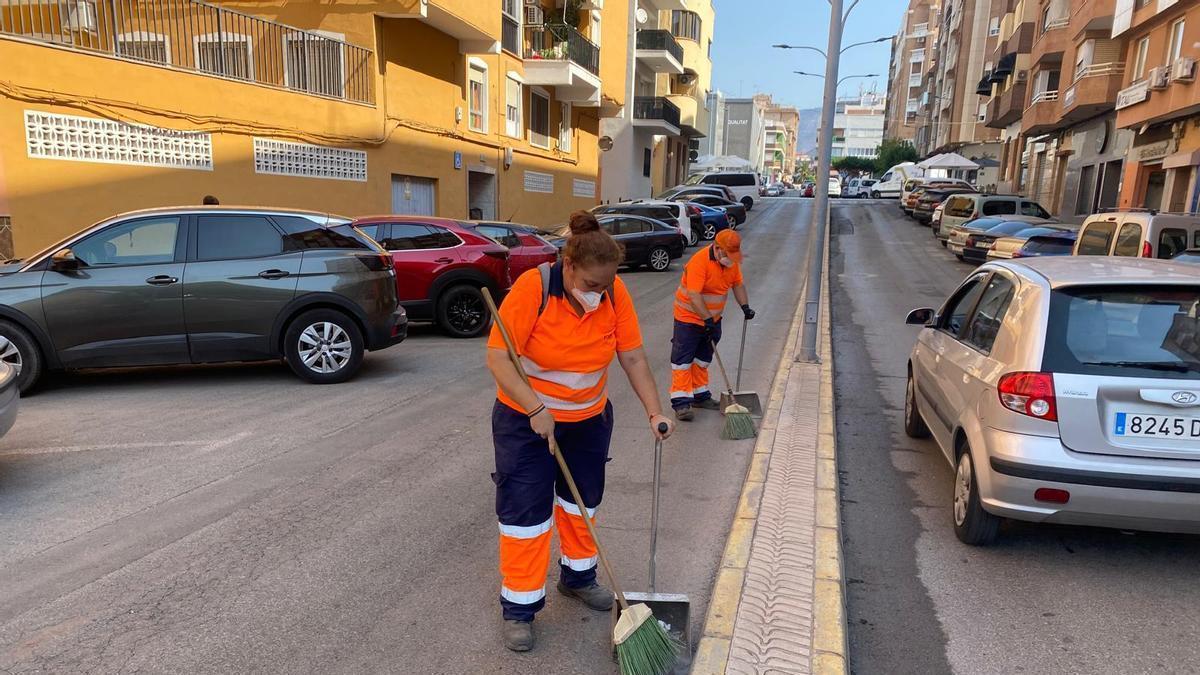 Dos empleados municipales recogen cenizas en una calle de la Vall d'Uixó este miércoles.