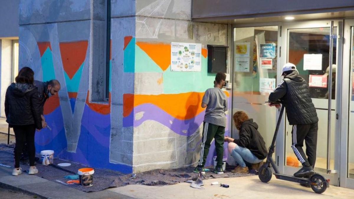 Joves pintant la façana de l’Espai Joves de Riudellots. | AJUNTAMENT DE RIUDELLOTS