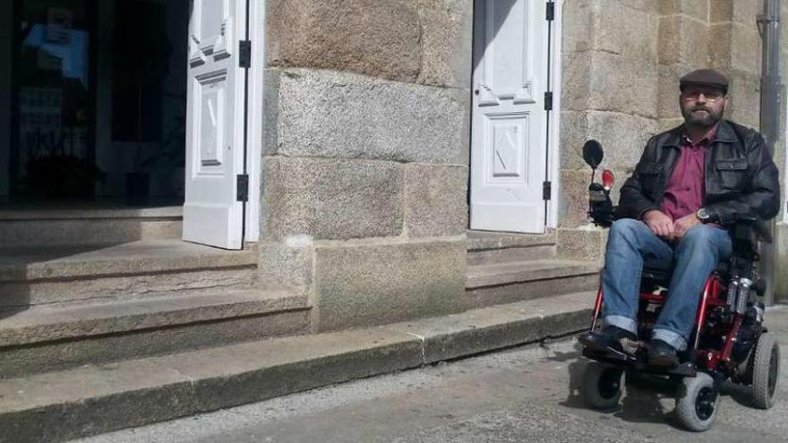 Un vecino de Betanzos, en silla de ruedas, frente a la entrada del Liceo.