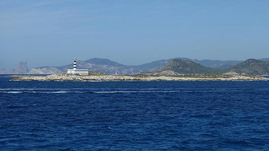 Es Penjats visto desde el mar y, al fondo, es Vedrà.