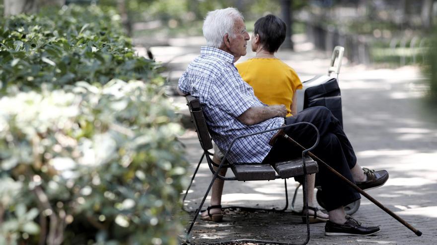 Un pensionista descansa en un banco de un parque de Madrid.