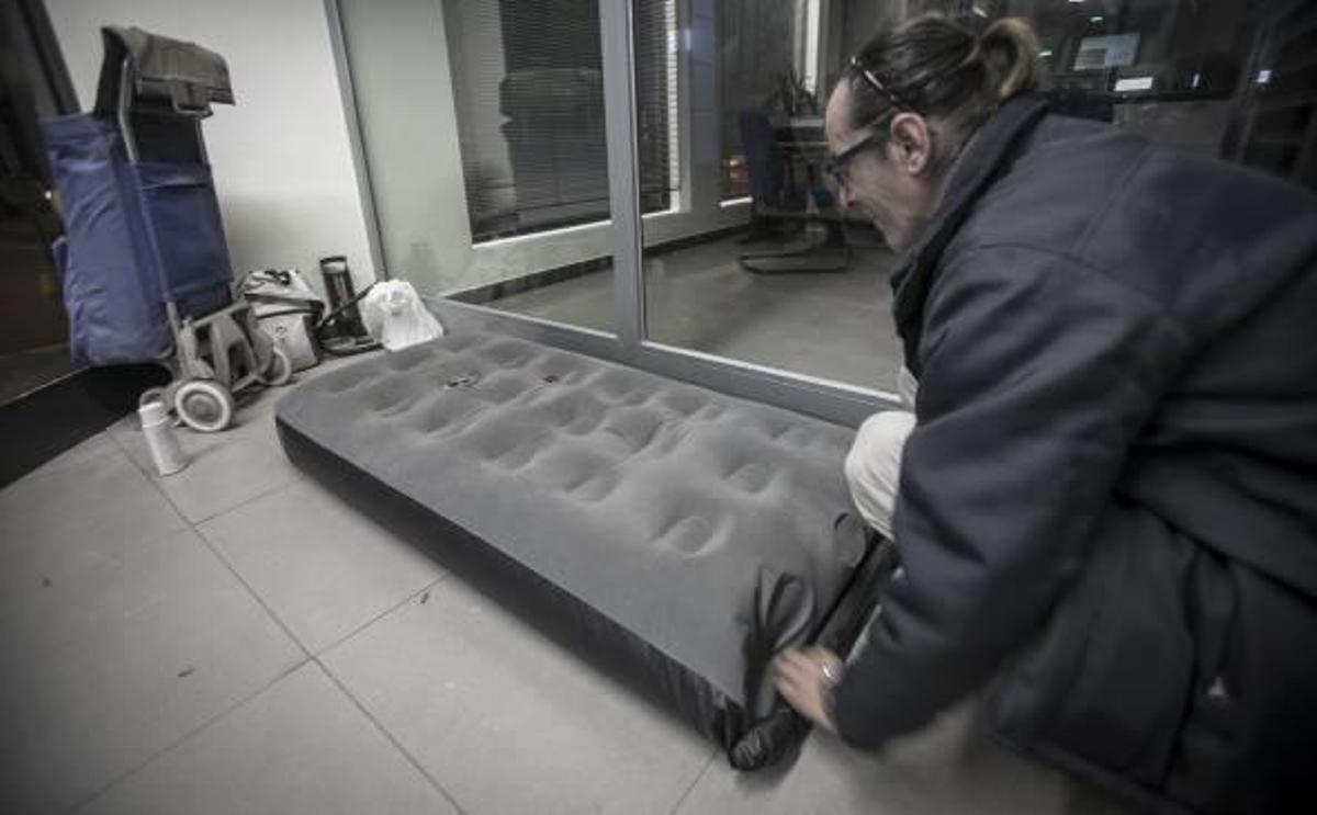 Dos personas sin techo se refugian en los cajeros de la ciudad para cobijarse del frío y poder dormir.