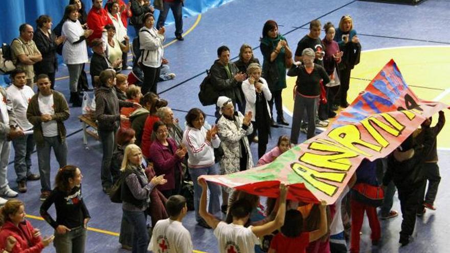 Niños y voluntarios portando un gran mural confeccionado para la ocasión.