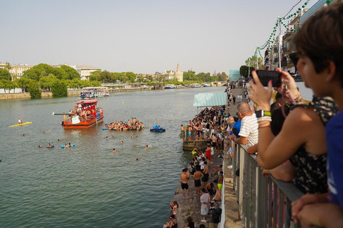 La 'cucaña', el juego centenario que regresa cada verano al río Guadalquivir por la Velá de Santa Ana en imágenes