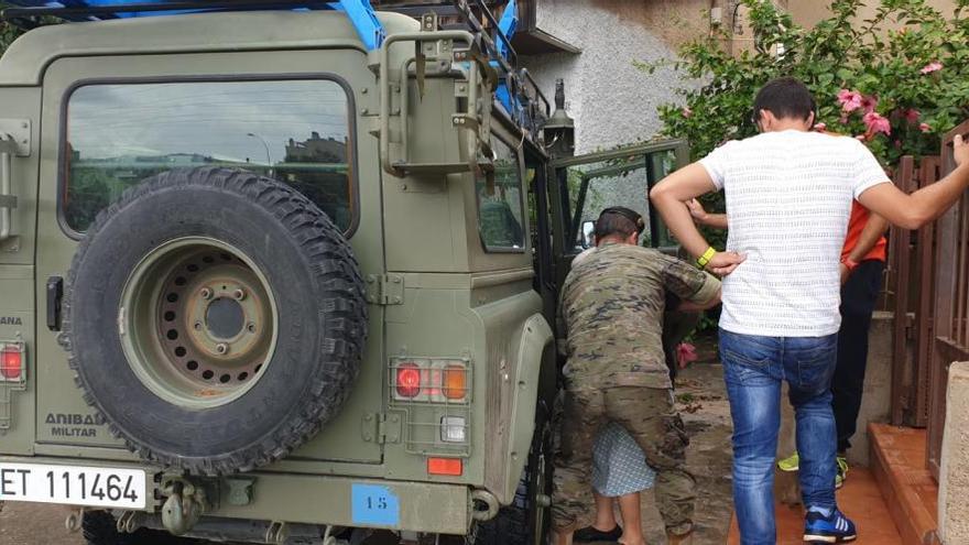 Militar ayudando a salir a una persona mayor en Rincón de Seca