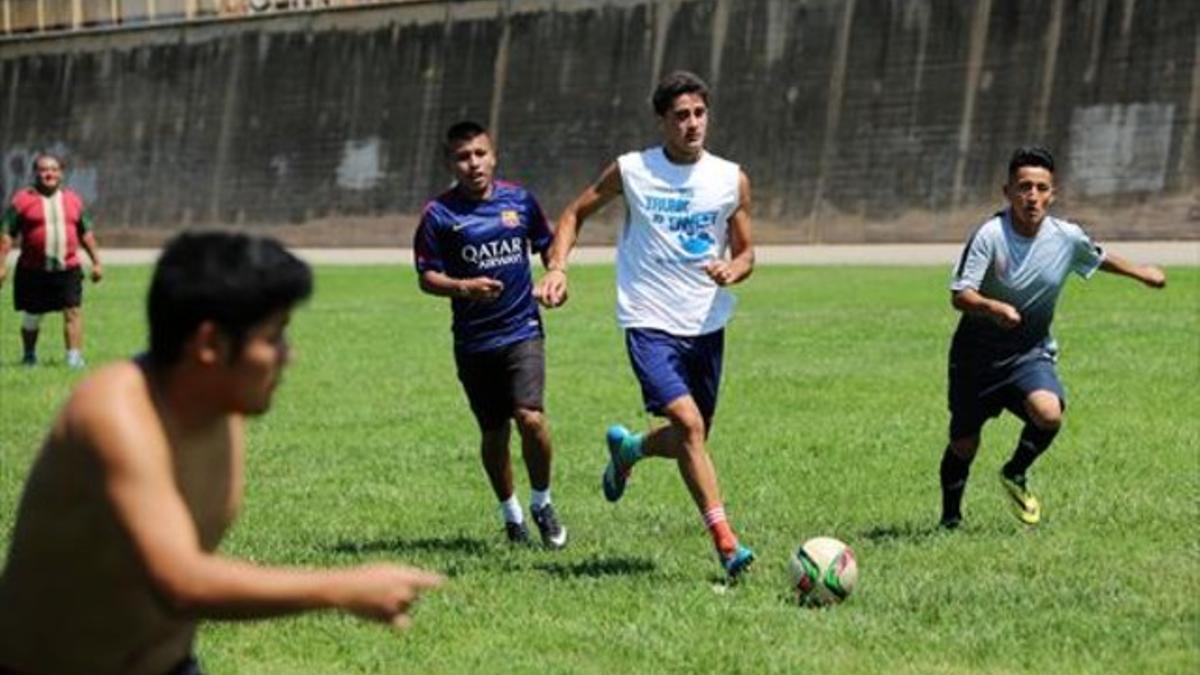 Lucas Turchi conduce la pelota durante un partido sobre el césped de la ribera del Besòs.