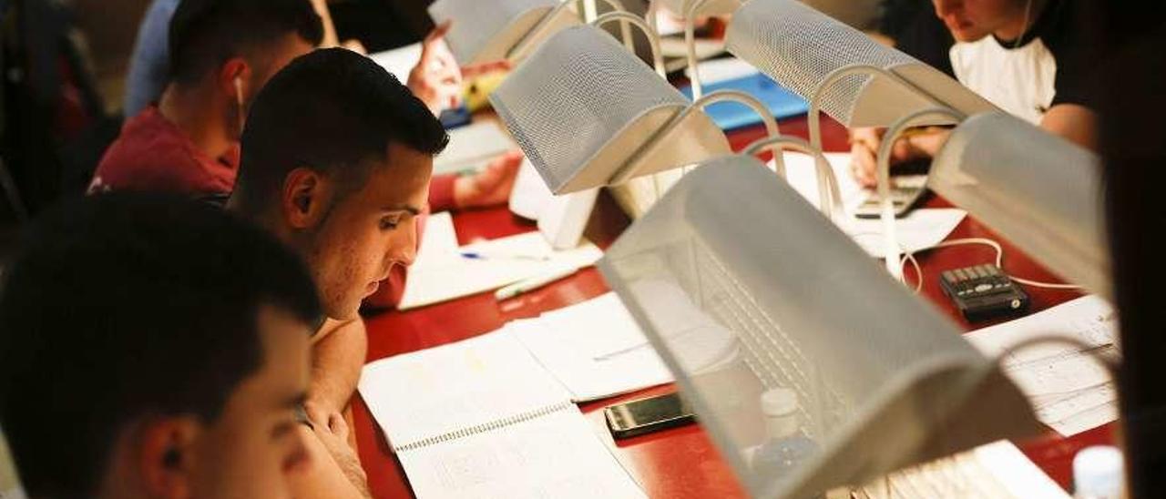 Alumnos estudiando en una biblioteca.