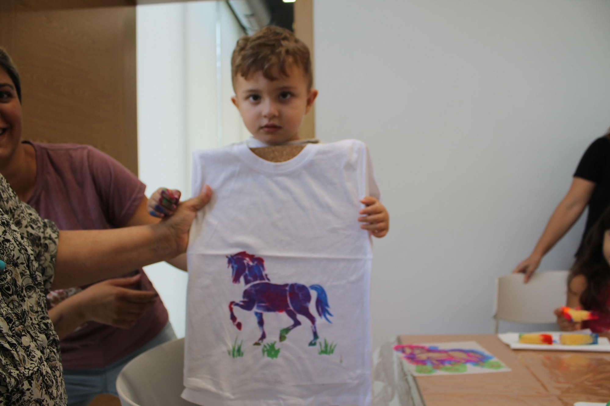 Galería de imágenes: Nietos y abuelos pintan camisetas en el taller de las fiestas de Cala de Bou