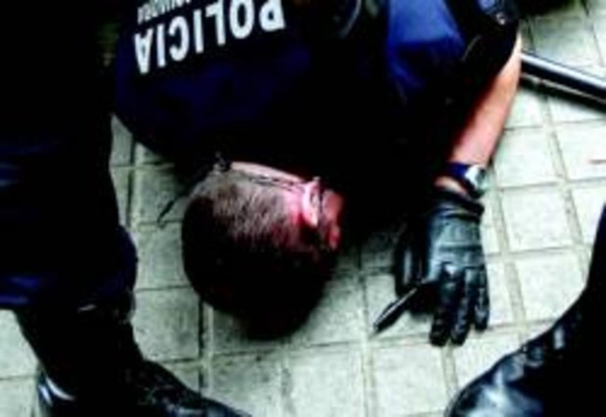 Un mosso, amb un ’kubotan’ a la mà, ferit a terra al carrer després de rebre un cop de puny, el 19 de maig del 2007.