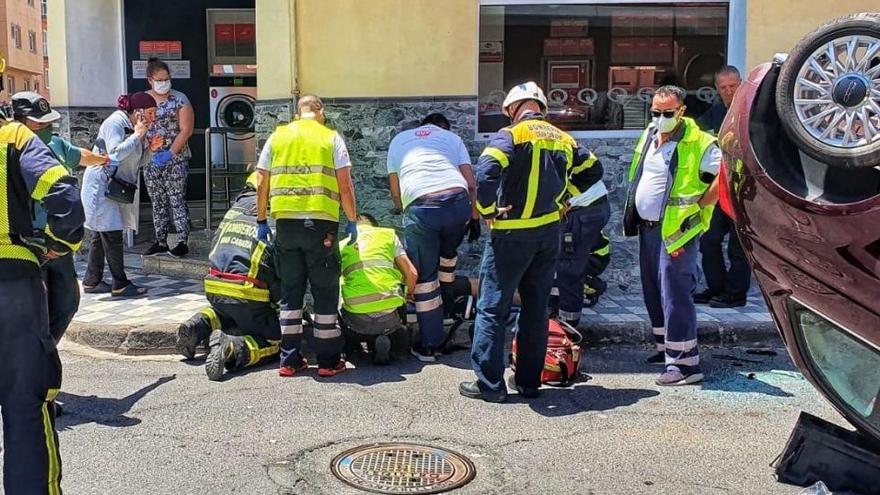 Los servicios de emergencia durante la atención al conductor del vehículo volcado.