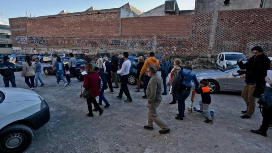 Un grupo de vecinos atraviesa el descampado de la polémica ubicado en El Toscar, muy próximo al colegio público Jaume I.