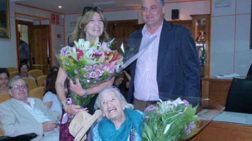 Enid Boundry y su hija reciben un ramo de flores de manos del alcalde, Javier Carnero.