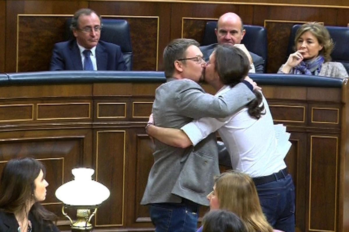 GRA251. MADRID, 02/03/2016.- Imagen tomada de la señal institucional del Congreso de los Diputados en la que aparecen el líder de Podemos, Pablo Iglesias (d), y el de En Comú Podem, Xavier Doménech, celebrando su estreno hoy en la tribuna de oradores de la Cámara Baja con un efusivo abrazo y un beso en los labios, al término de la intervención del diputado catalán, durante la segunda jornada del debate de investidura del líder socialista, Pedro Sánchez. EFE/