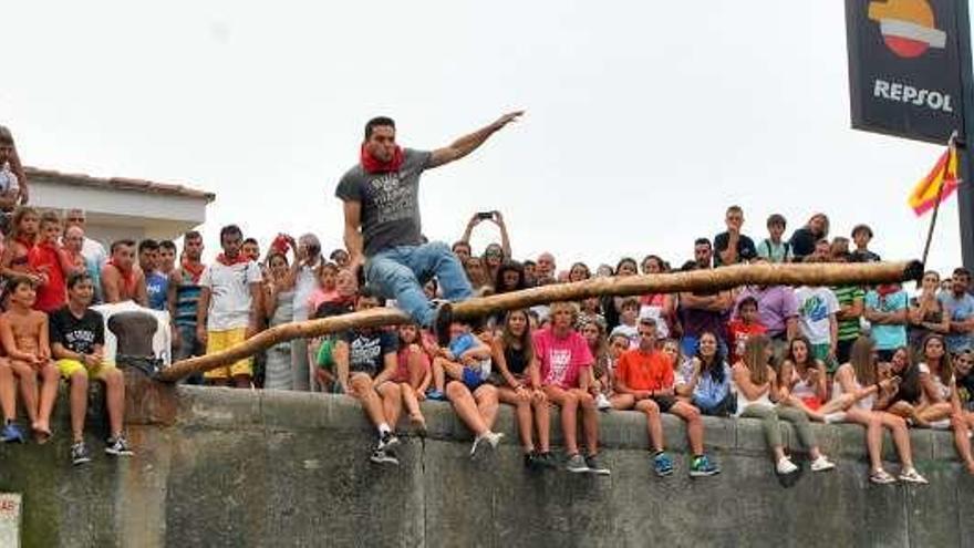 Un participante en el juego de la cucaña.