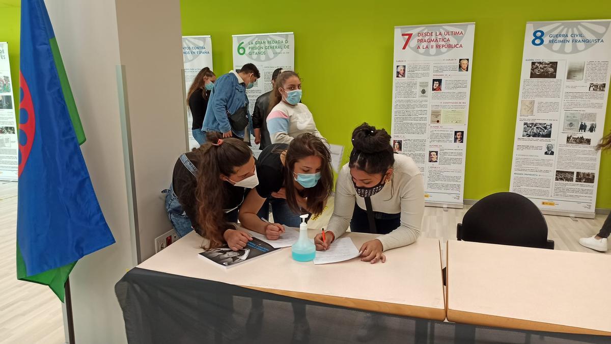 Unas estudiantes del centro toman notas de la exposición en la sede de la Asociación para la Promoción del Pueblo Gitano de Zaragoza.
