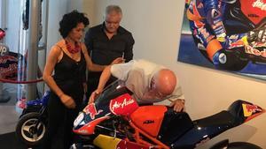 Toni Salom, abuelo del fallecido joven piloto mallorquín, besa, entre lágrimas, la moto de su nieto Luis, en la inauguración hoy de una exposición en Palma.