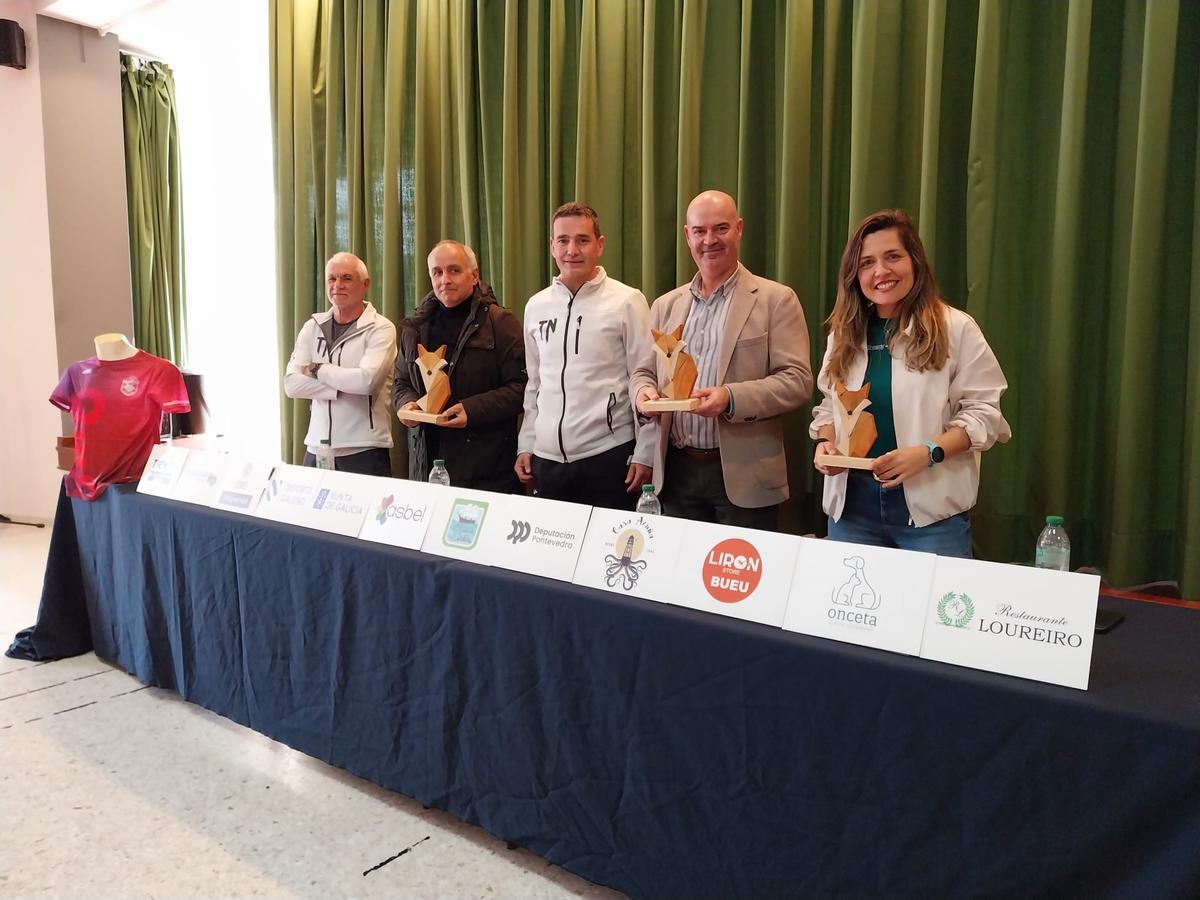 De izq. a dcha.: Pepe «Cachiso», Daniel Benavides, Marcos Torres, Félix Juncal y Xisela Aranda en la Casa do Pobo de Beluso con los trofeos del V Trail do Nocedo.