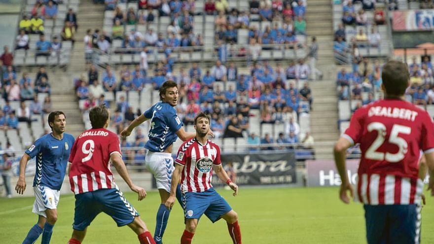 Vila salta por encima de un jugador del Lugo, con David Fernández a la izquierda, en el Tartiere.