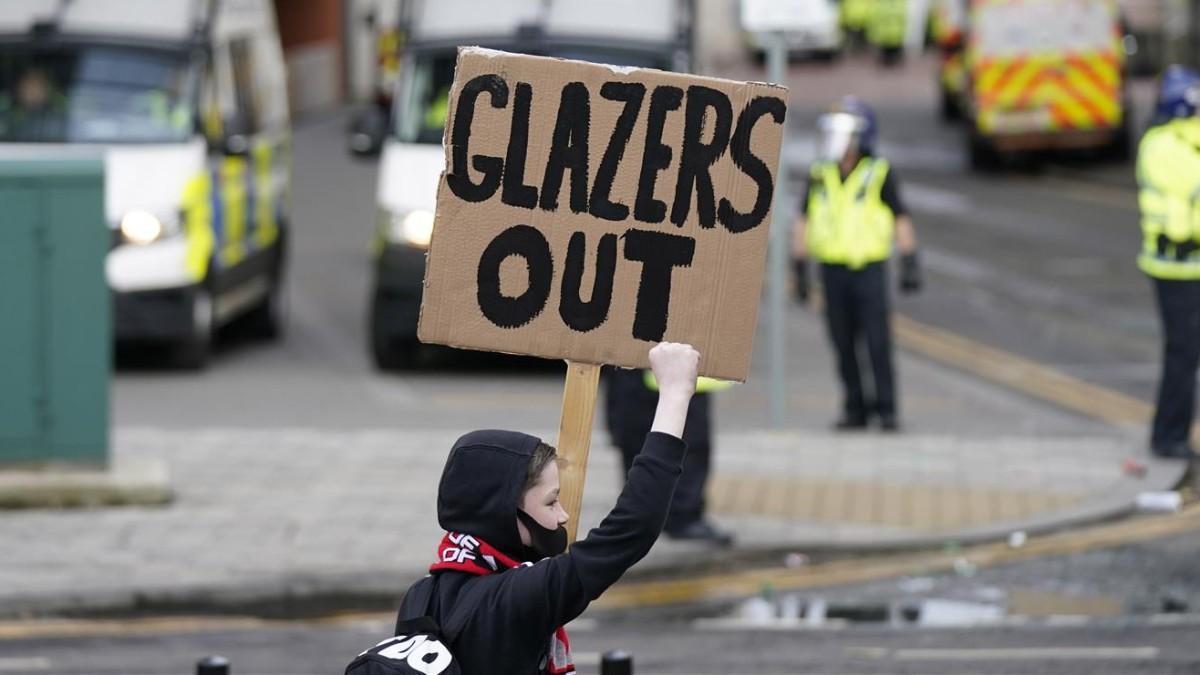 Un joven aficionado con una pancarta contra los Glazer