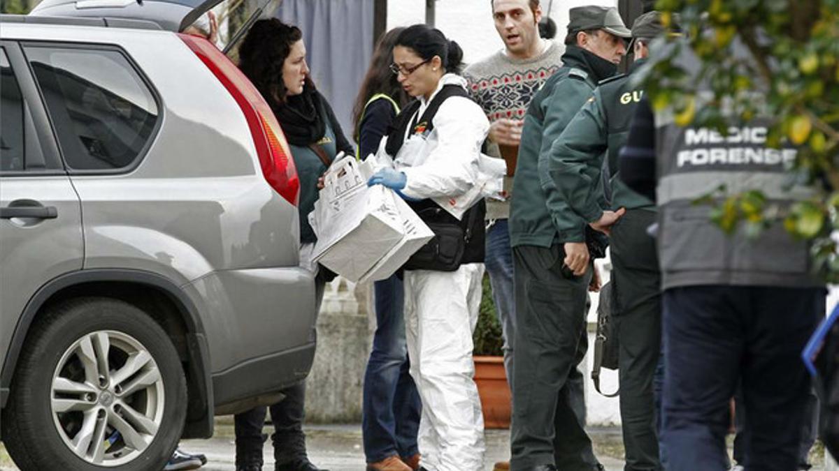 Agentes judiciales y de la Guardia Civil salen de una de las viviendas, en el municipio lucense de Cervo, donde encontraron dos cadáveres