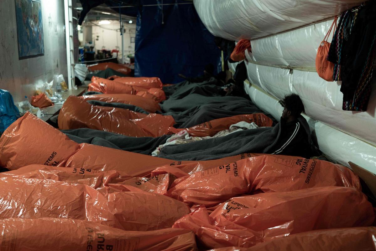 Migrantes descansando a bordo del barco de rescate Ocean Viking de la organización humanitaria marítima europea SOS Mediterranee en aguas internacionales en el golfo de Catania