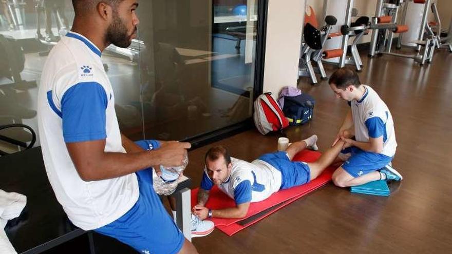 El fisio del equipo atiende a Carlinos en el gimnasio.