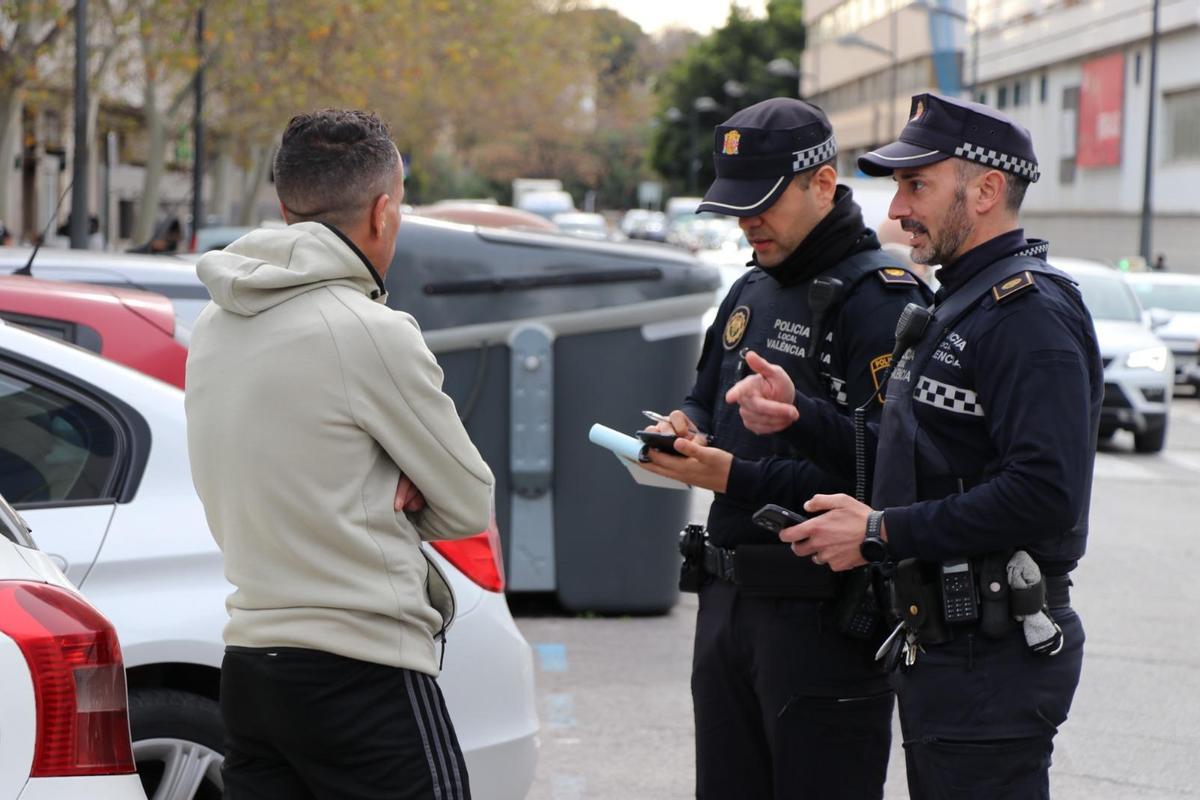Dos agentes de Policía Local identificando y sancionando a un gorrilla