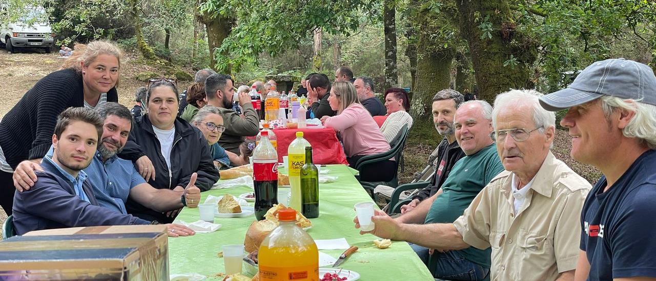 Iván Caamaño (1º i.), Andrés Quintá (2º d.) y otros asistentes a la tradicional comida campestre de San Cibrán, ayer.