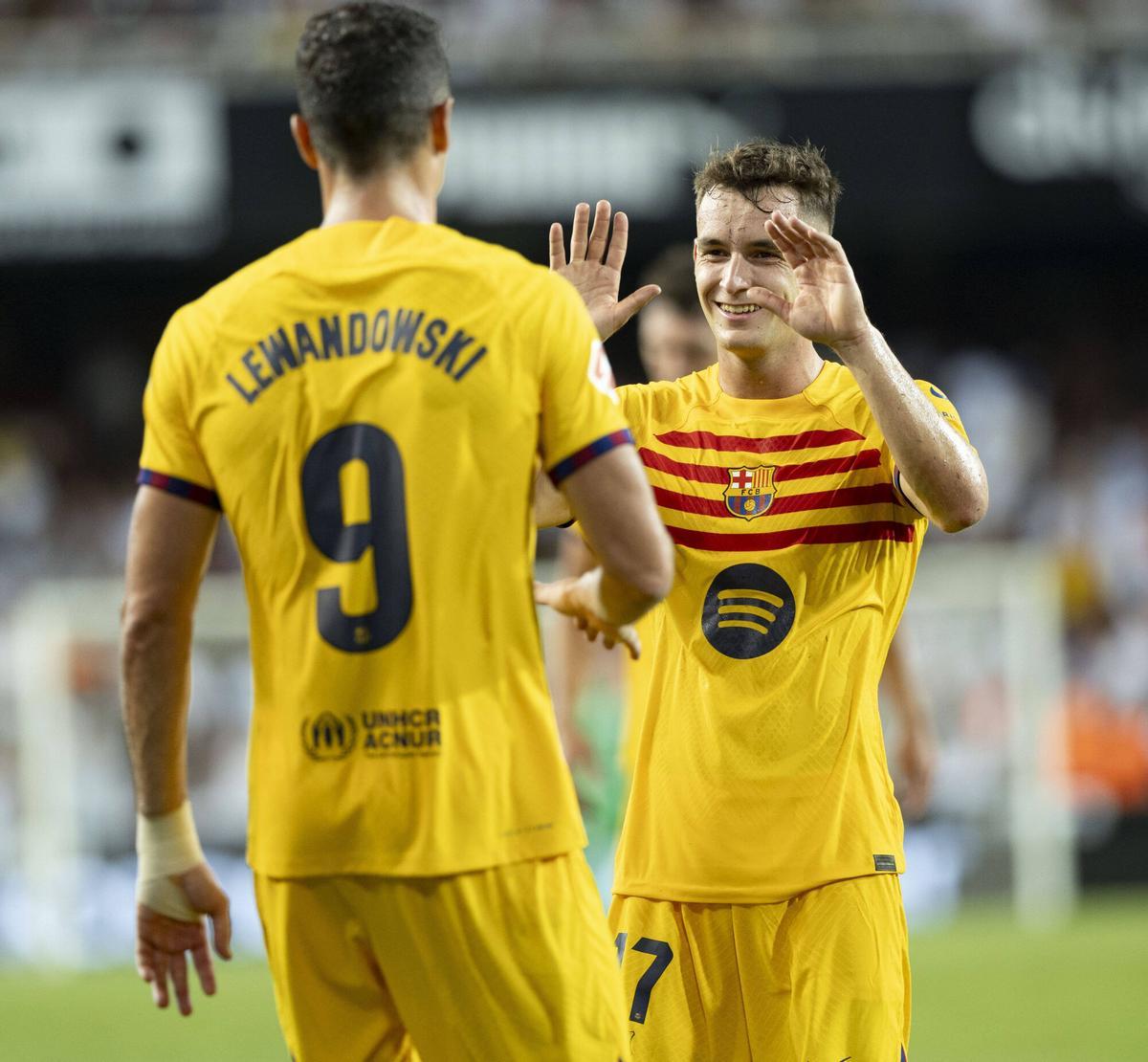 Marc Casadó se acerca a felicitar a Lewandowski tras el doblete de Mestalla.