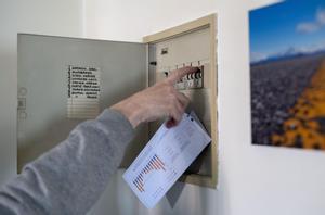 Un hombre sube los plomos de la luz con una factura de luz en la mano, en Madrid, (España).