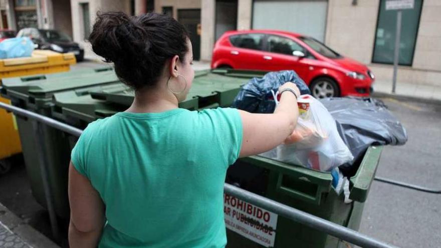 Una ciudadana deposita basura en un contenedor. // Bernabé/Luismy