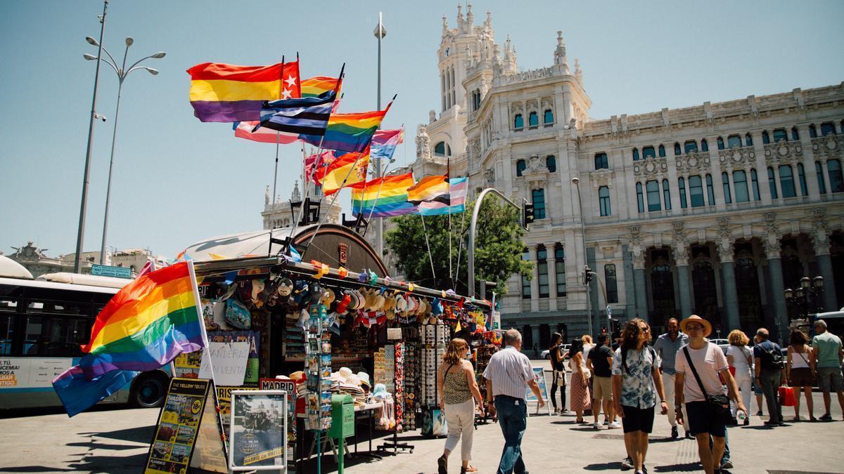 Banderas del orgullo ondean en quioscos frente al Ayuntamiento de Madrid.
