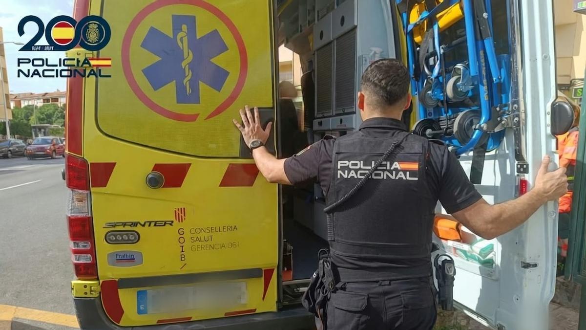 Un agente de la Policía Nacional ante una ambulancia en un centro sanitario.