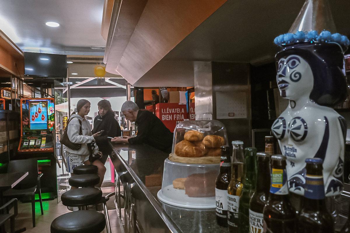 Miguel Ángel atendiendo a dos clientes de su bar.