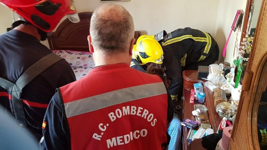 Los bomberos asisten a la mujer en su dormitorio.